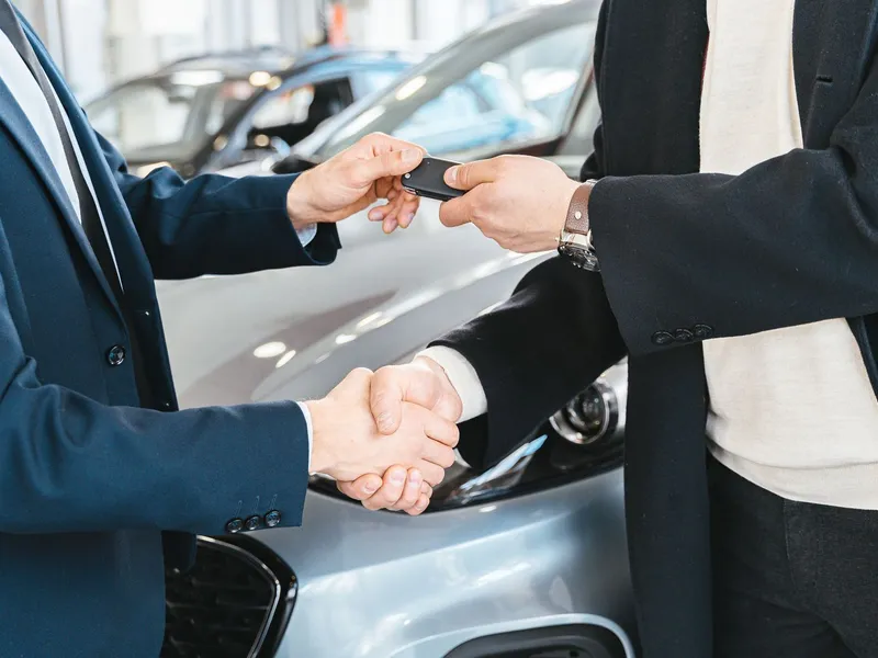 Entrega da chave do carro com aperto de mão