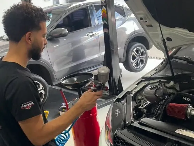 Mecânico da Forza no motor de um Golf